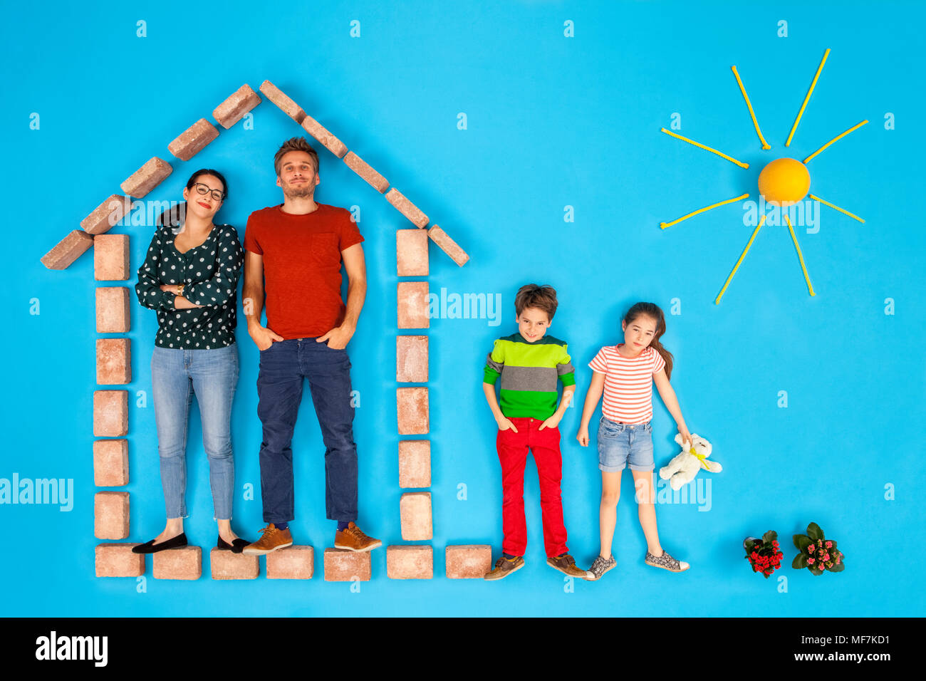 I genitori in piedi in casa, mentre i bambini giocano in giardino Foto Stock