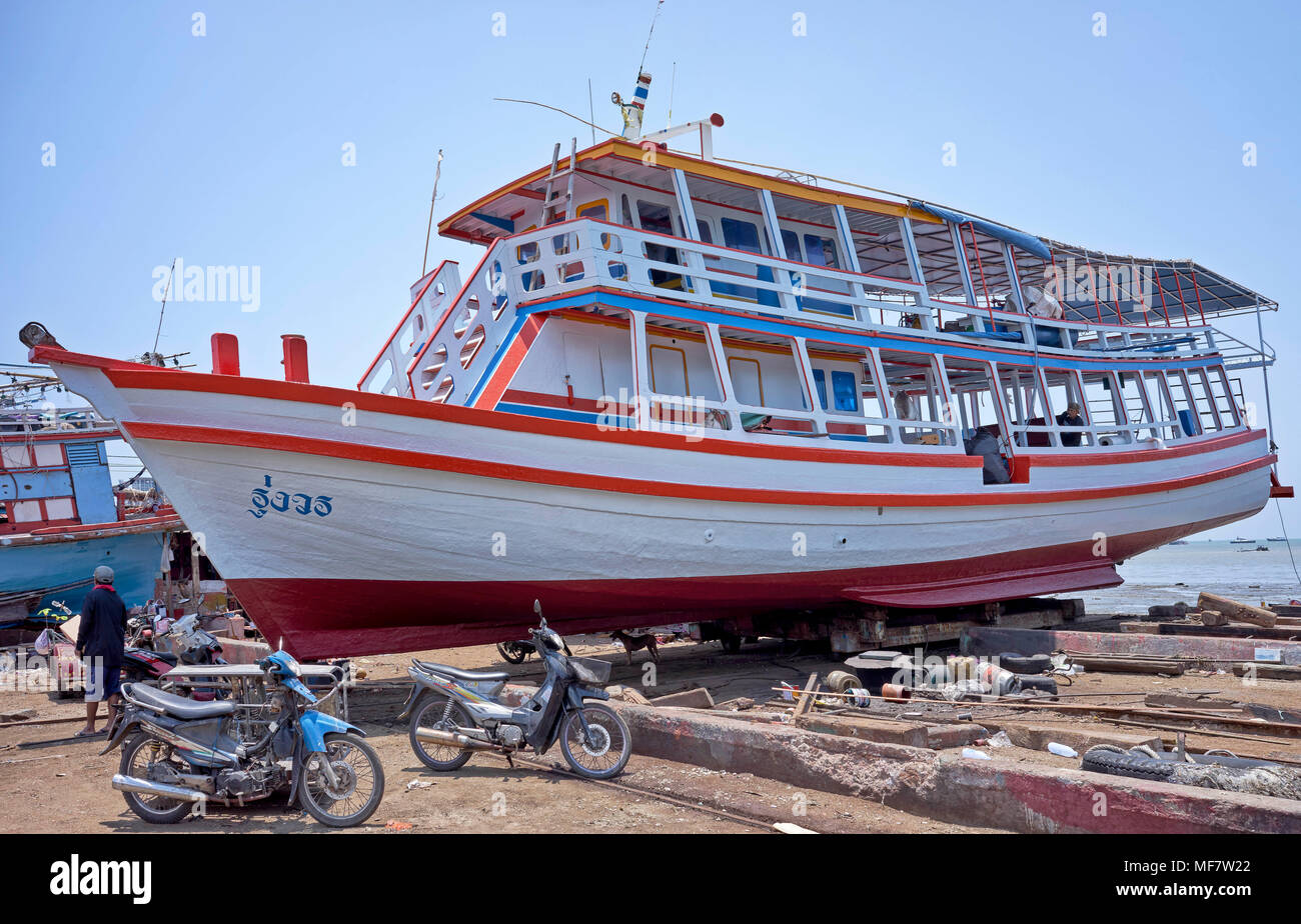 Cantiere di riparazione e ristrutturazione con barca turistica tailandese tradizionale in corso di riverniciatura, Thailandia, Sud-Est asiatico Foto Stock