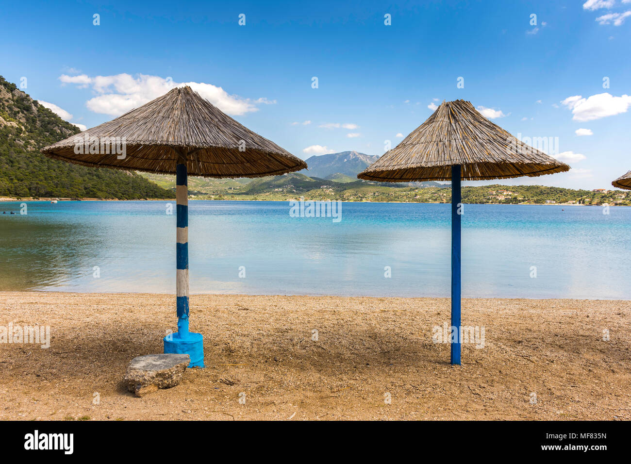 Ombrelloni di paglia sulla spiaggia sabbiosa in Grecia Foto stock - Alamy