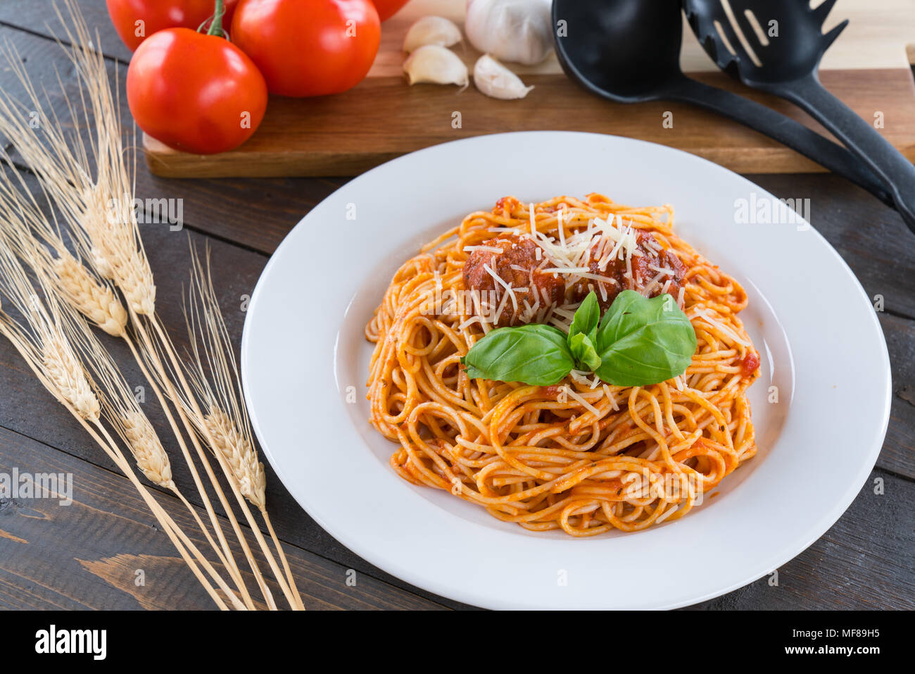 Piatto di spaghetti con sugo di pomodoro, polpette e basilico Foto Stock