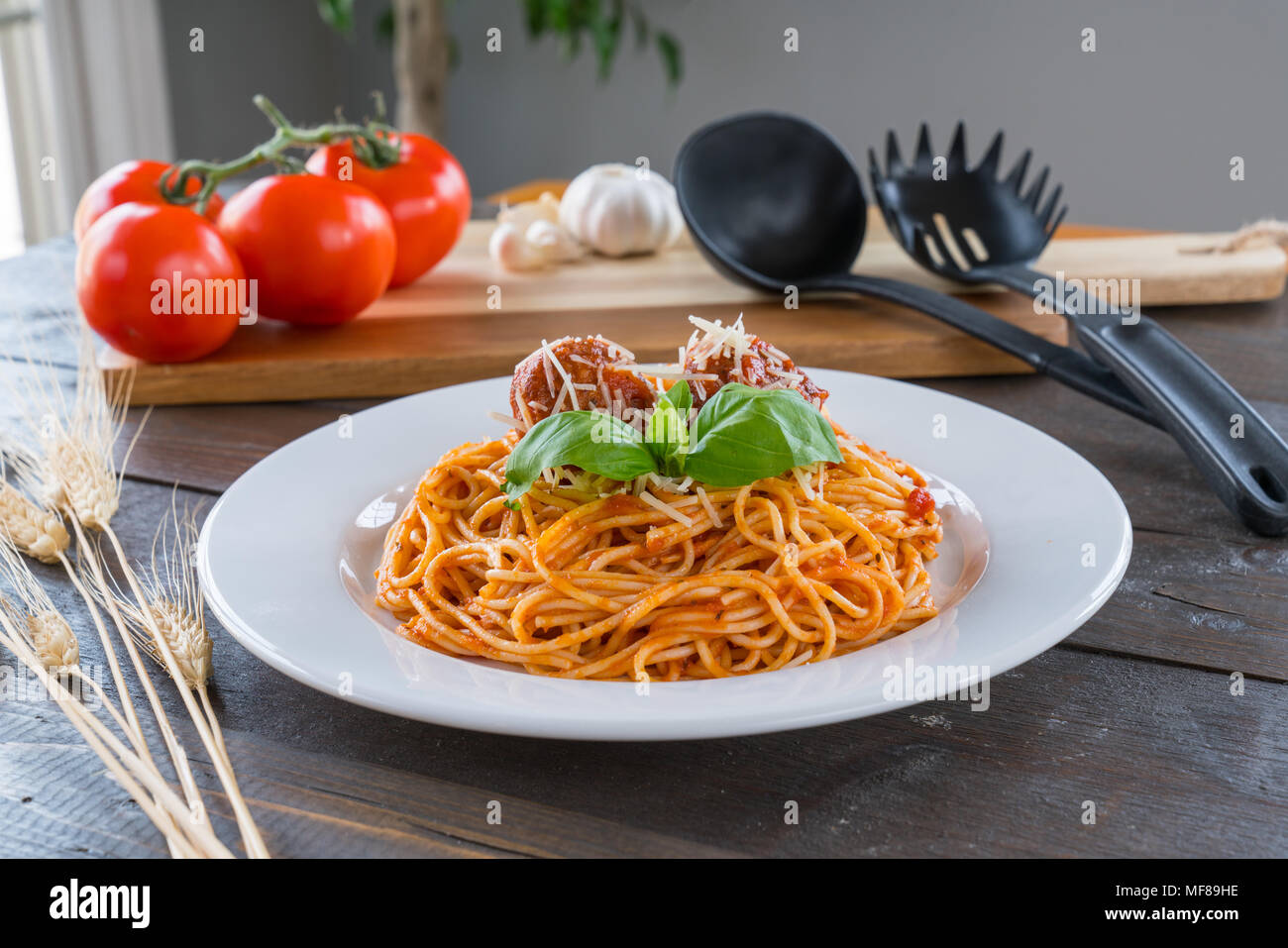 Piatto di spaghetti con sugo di pomodoro, polpette e basilico Foto Stock