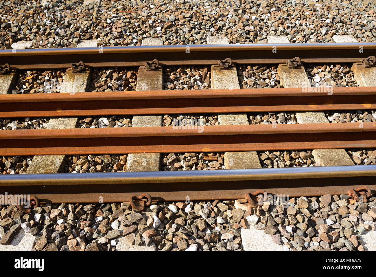 Di ricambio a lungo rotaie saldate memorizzati tra una delle linee in esecuzione. Foto Stock