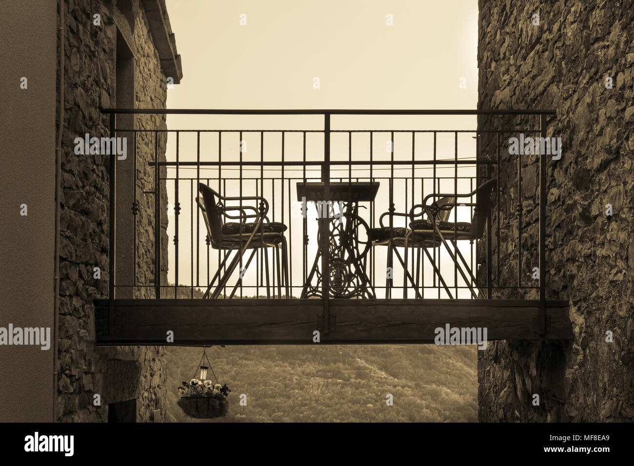 Terrazza con sedie tra due case, tonificazione seppia Foto Stock