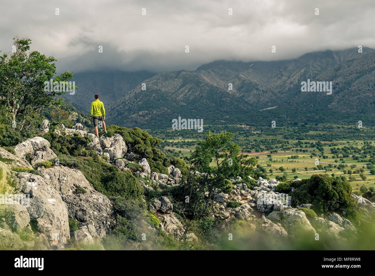 Escursionismo uomo guardando belle montagne paesaggio di ispirazione. Escursionista trekking con zaino sul sentiero roccioso sentiero. Un sano stile di vita fitness fuori Foto Stock