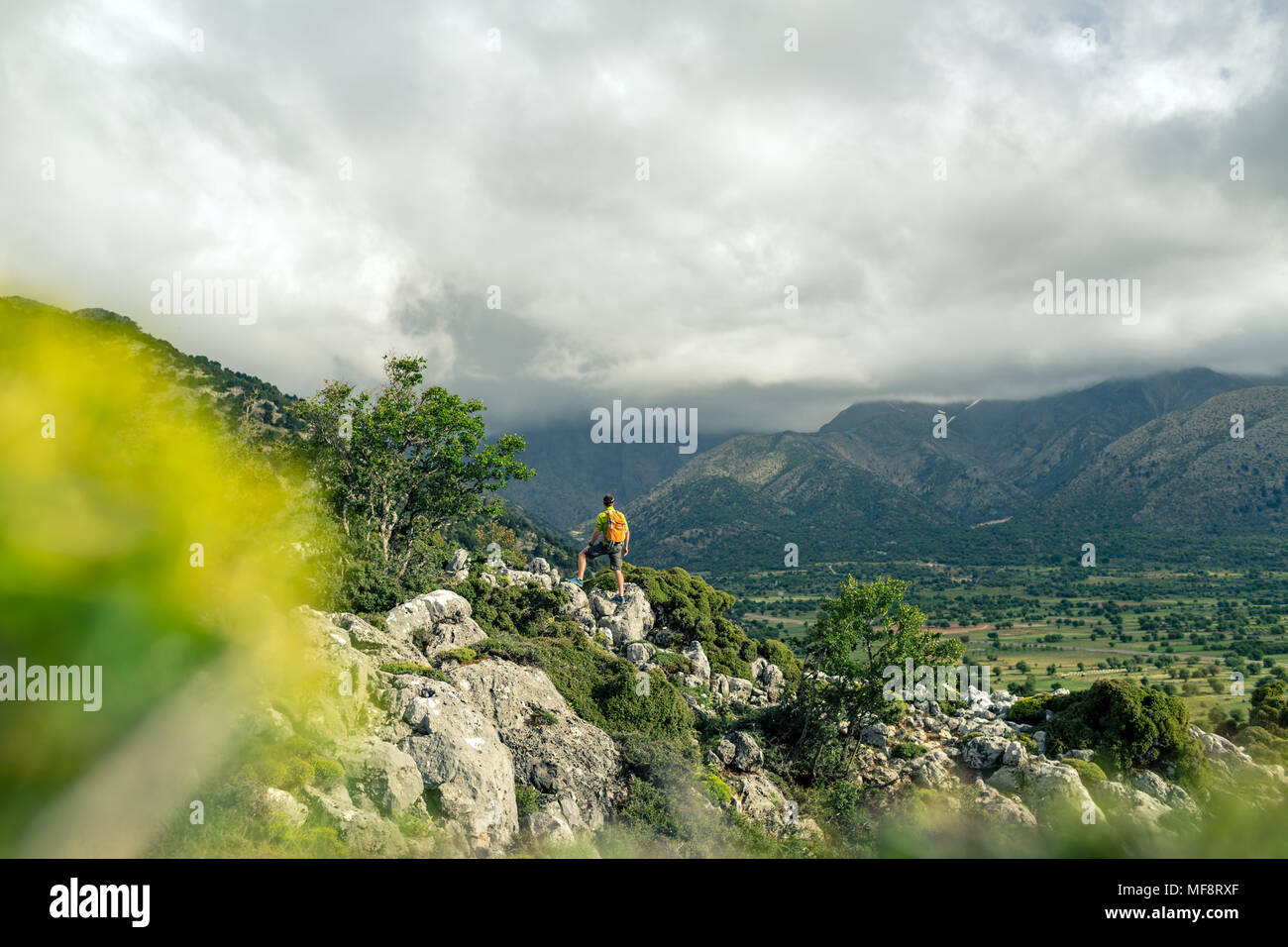 Escursionismo uomo guardando belle montagne paesaggio di ispirazione. Escursionista trekking con zaino sul sentiero roccioso sentiero. Un sano stile di vita fitness fuori Foto Stock