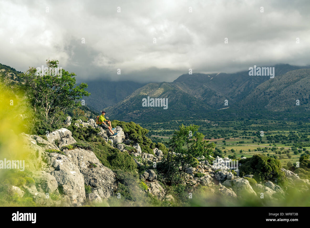 Escursionismo uomo guardando belle montagne paesaggio di ispirazione. Escursionista trekking con zaino sul sentiero roccioso sentiero. Un sano stile di vita fitness fuori Foto Stock