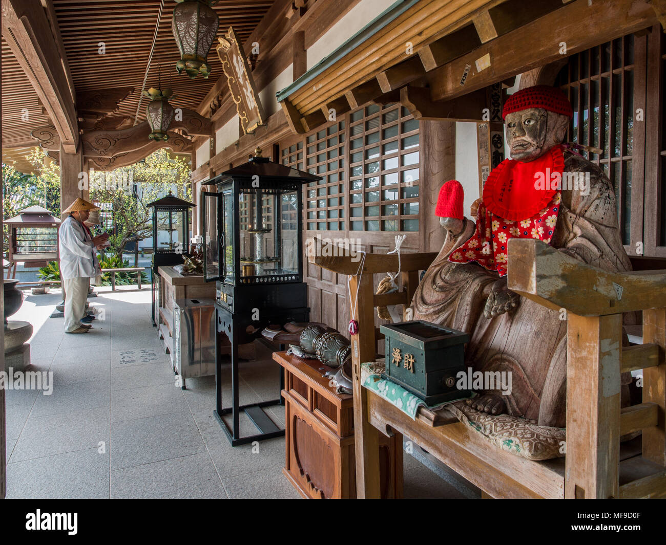 Pellegrino Henro pregando e Binzuru sonja, dio giapponese di guarigione, Kanjizaiji, Shikoku Giappone Foto Stock