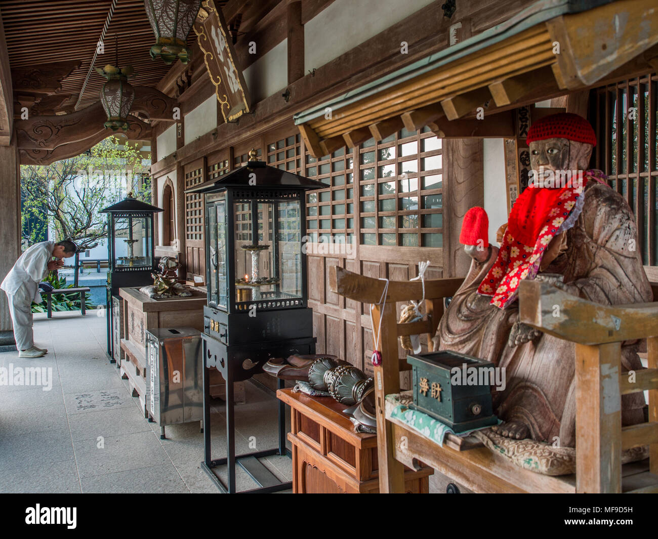 Pellegrino Henro pregando e Binzuru sonja, dio giapponese di guarigione, Kanjizaiji, Shikoku Giappone Foto Stock