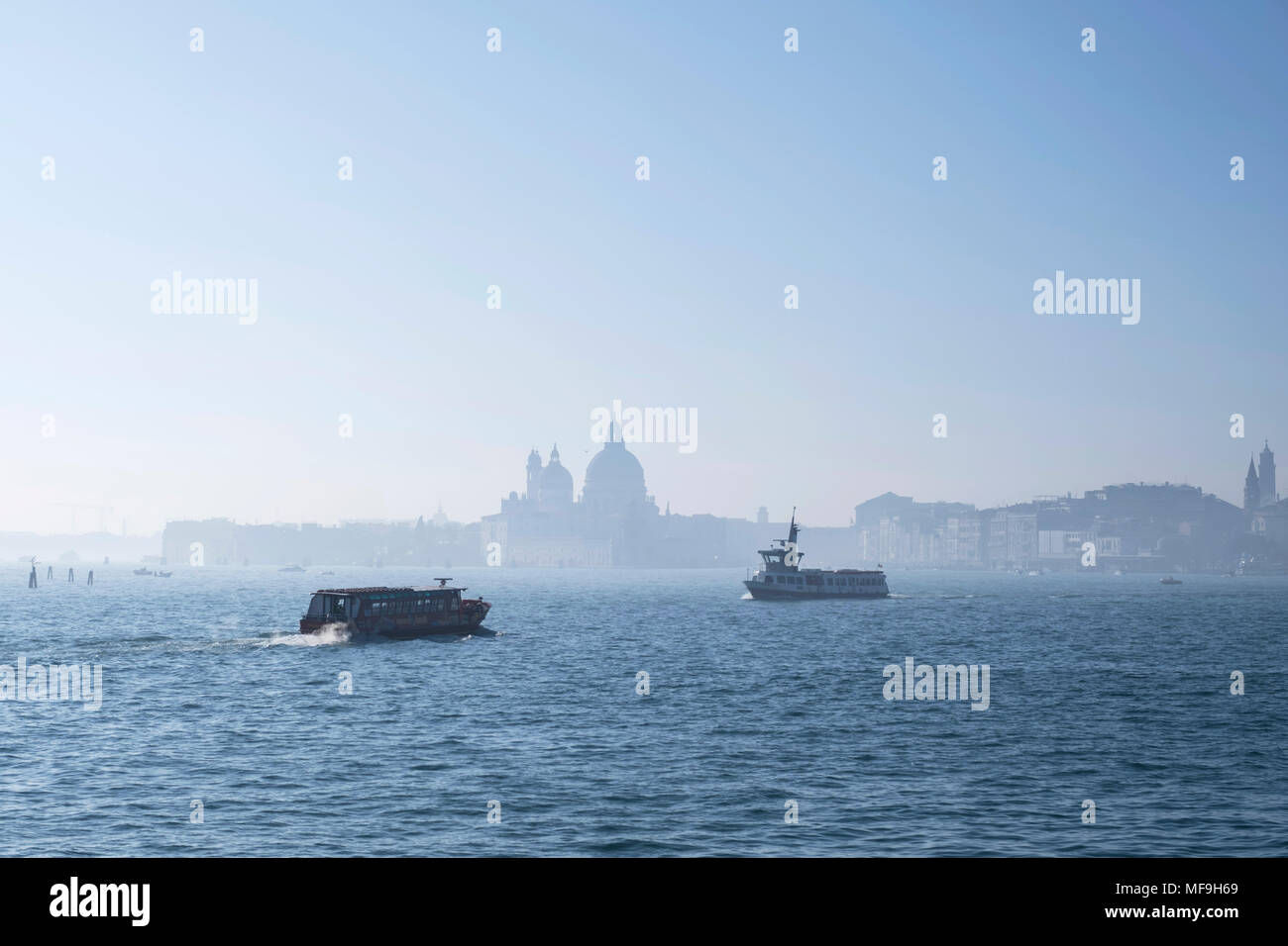 Le imbarcazioni che passano la laguna di Venezia, Italia, in una nebbiosa mattina Foto Stock
