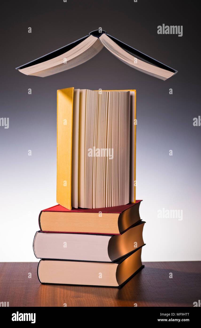 Tre libri impilati con un libro su di esso e un galleggiante sopra tutti loro. Foto Stock