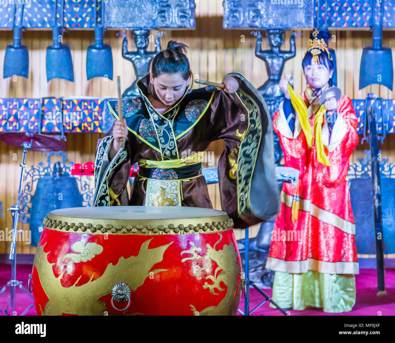 Due donne cinesi musicisti in kimono, una riproduzione di un grande tamburo rosso, l'altra parte di cembali, durante una performance presso la Torre del Tamburo, Xian, Cina. Foto Stock