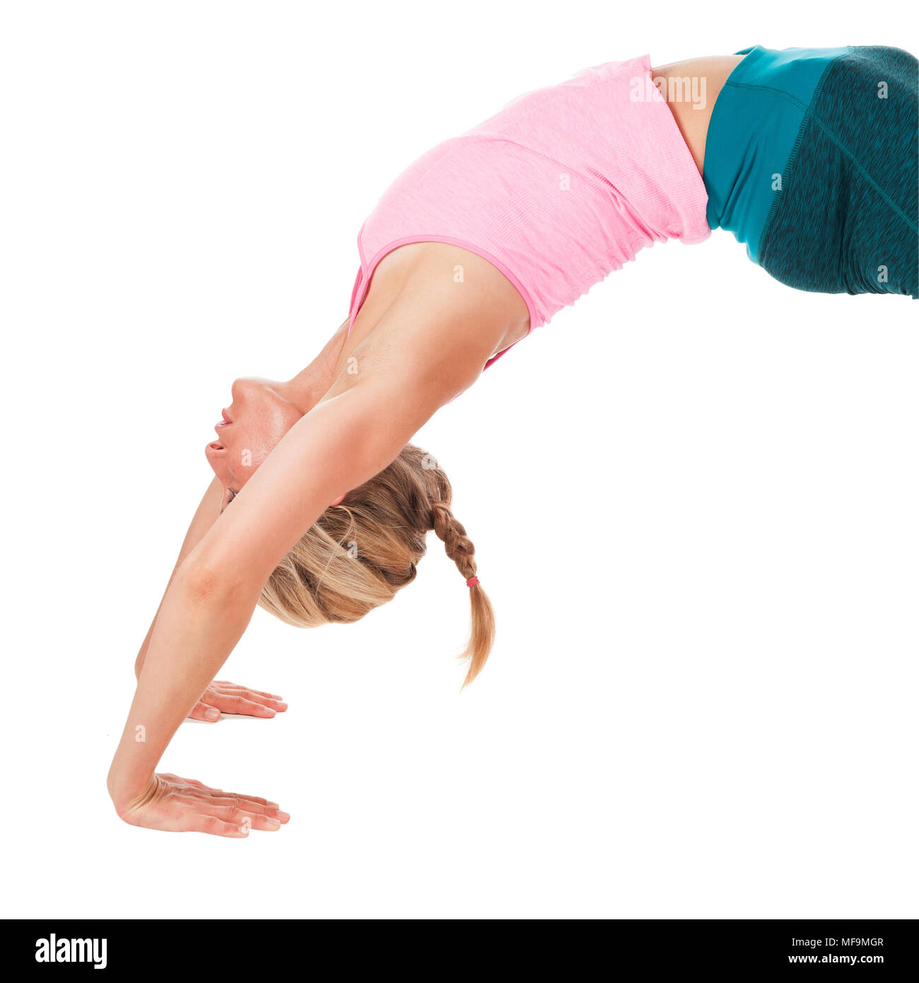 Parte superiore laterale vista del corpo di una giovane donna di fronte a uno sfondo bianco nella posizione di yoga il ponte (Chakrasana). Foto Stock