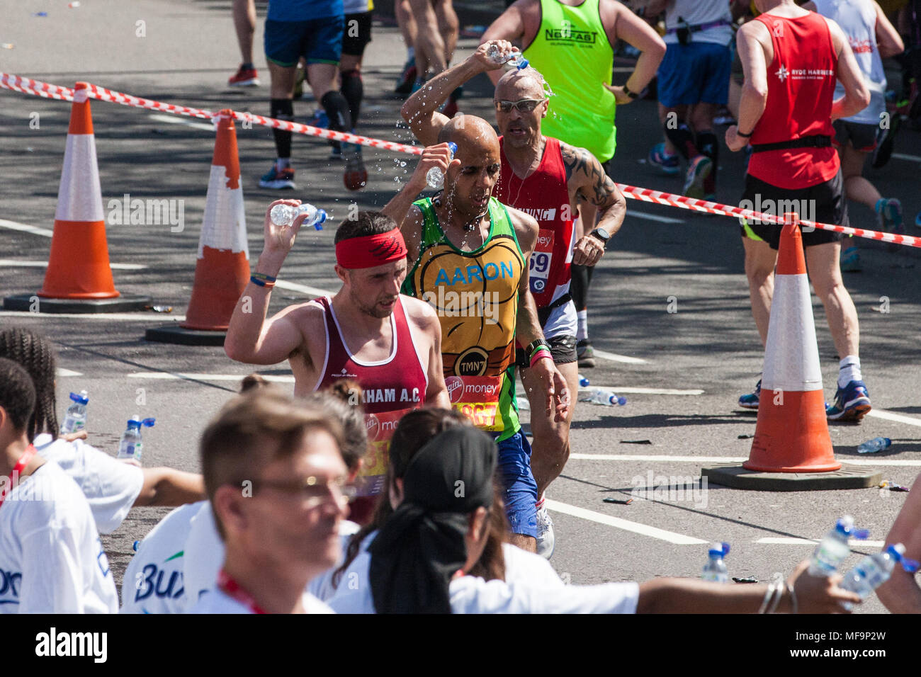 Londra, Regno Unito. Il 22 aprile, 2018. I corridori assumere acqua nel record di temperatura in corrispondenza della Vergine denaro maratona di Londra. Foto Stock