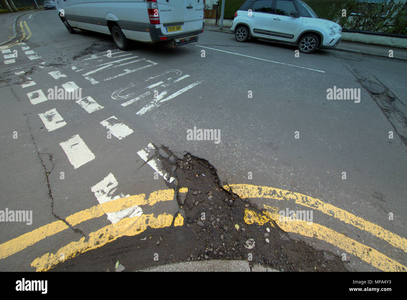 Pot fori strada danneggiata auto automobili su strada con il doppio di linee gialle nessuna voce iscrizioni Foto Stock
