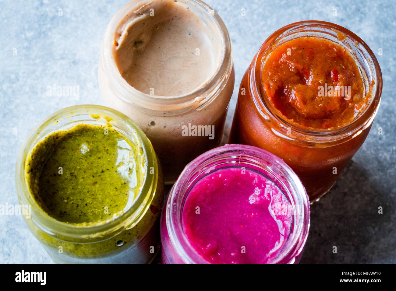 Vasetto di barbabietole salsa Dip, burro di mandorla o Tahini Urbech pistacchio e Salsa (pomodoro) salsa. Alimenti biologici. Foto Stock