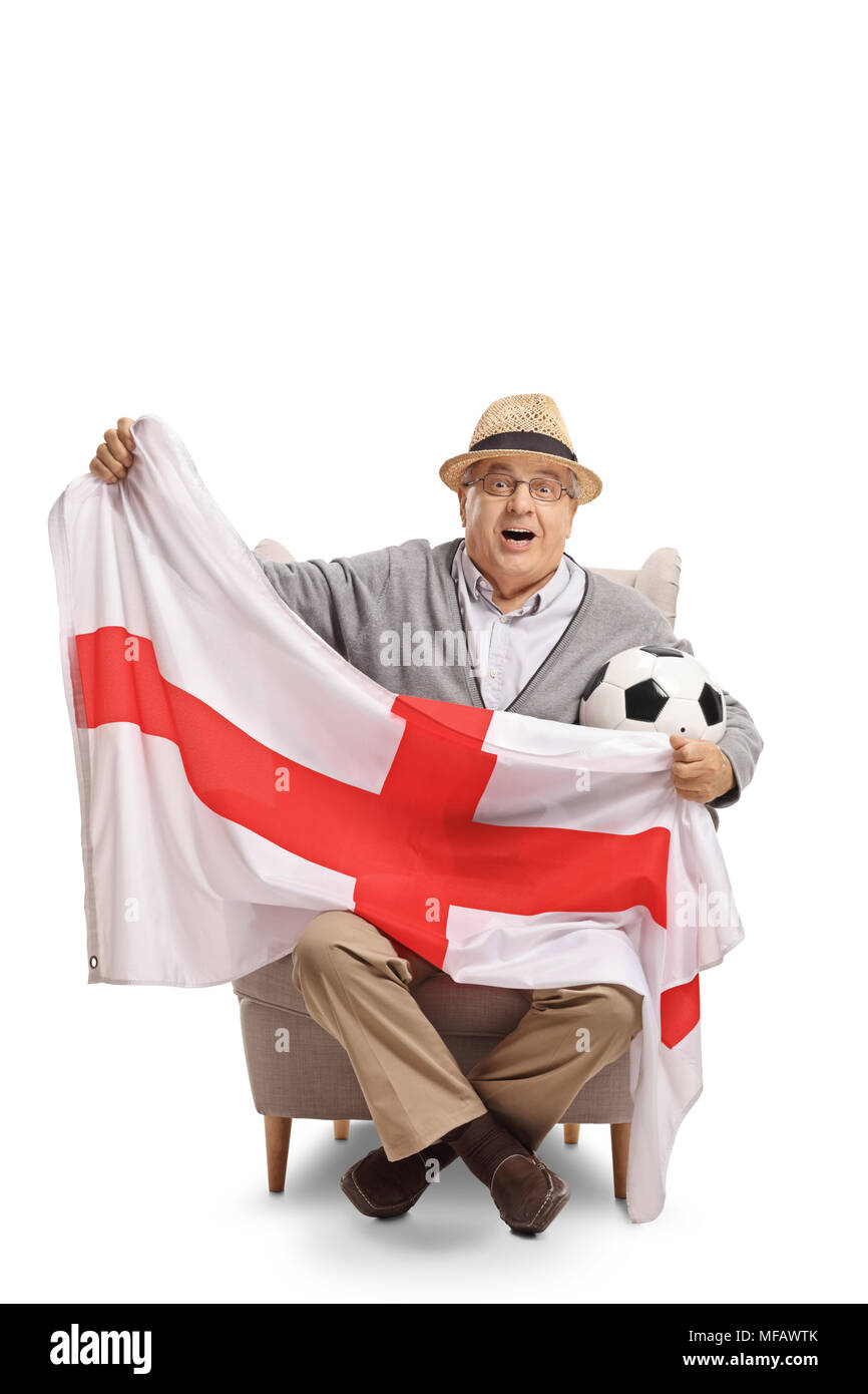 Emozionato anziani tifoso di calcio seduto in poltrona e tenendo una bandiera inglese isolato su sfondo bianco Foto Stock