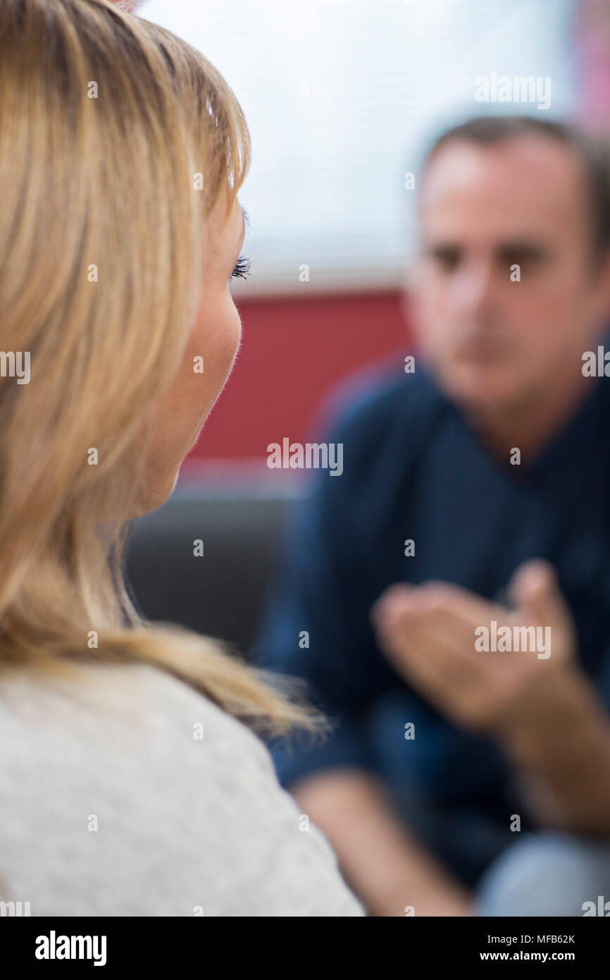 Vista posteriore della depressione donna matura parlando al Consigliere Foto Stock