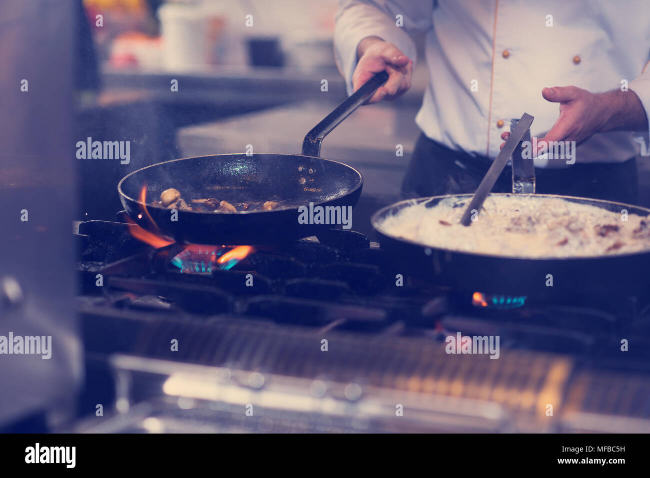 Lo chef prepara cibi, frittura in padella wok. La vendita e il concetto di cibo Foto Stock