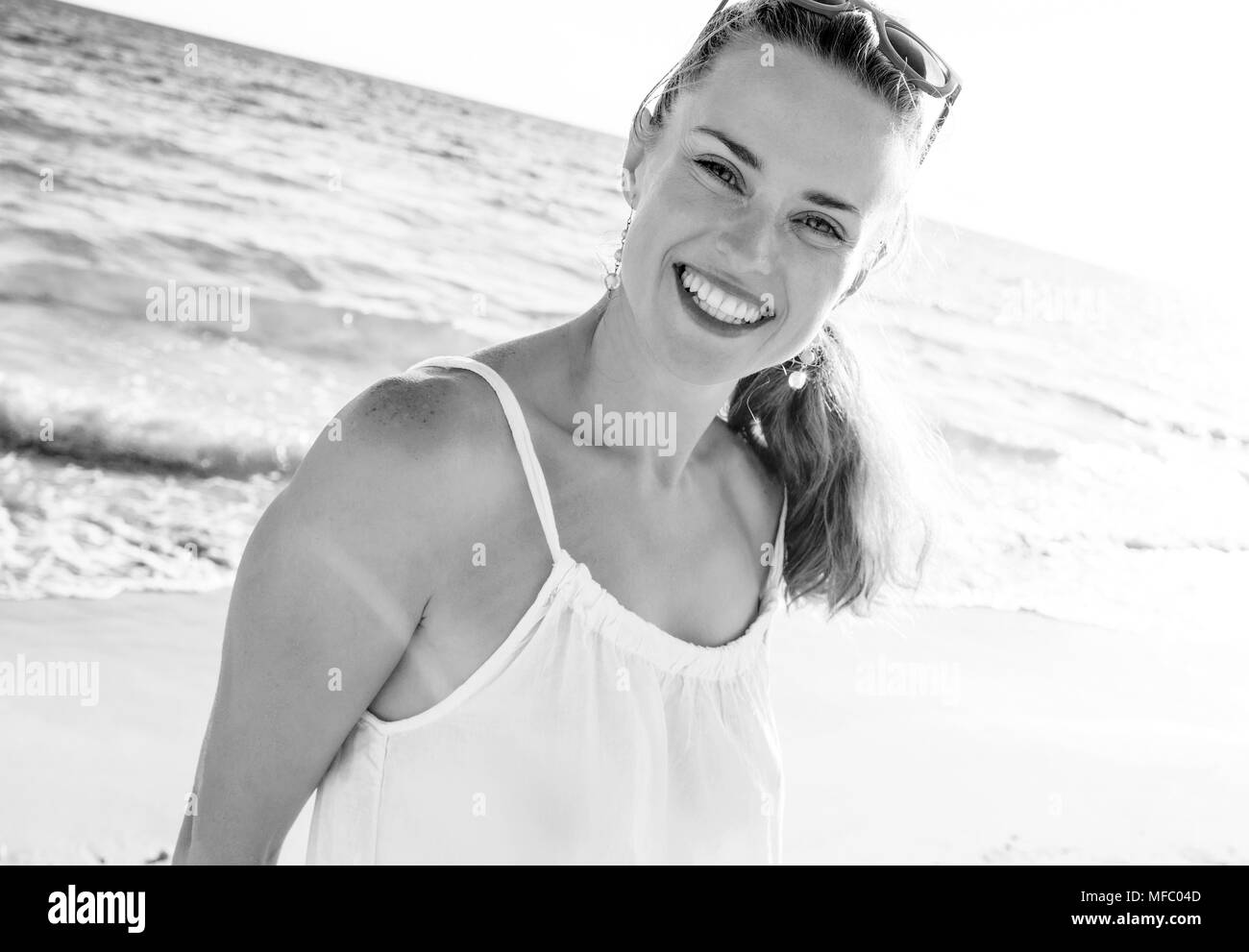 Meravigliosamente buon umore. sorridente giovane donna in abiti sul Seacoast di sera Foto Stock