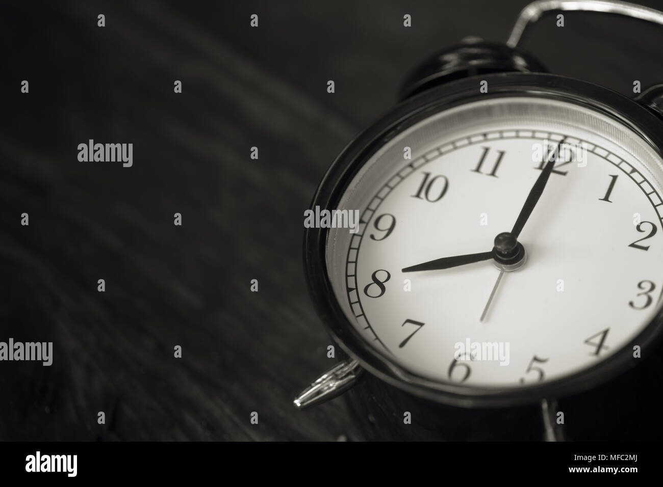 Vecchio orologio in stile retrò visualizza 8 ore su uno sfondo di legno. Foto Stock