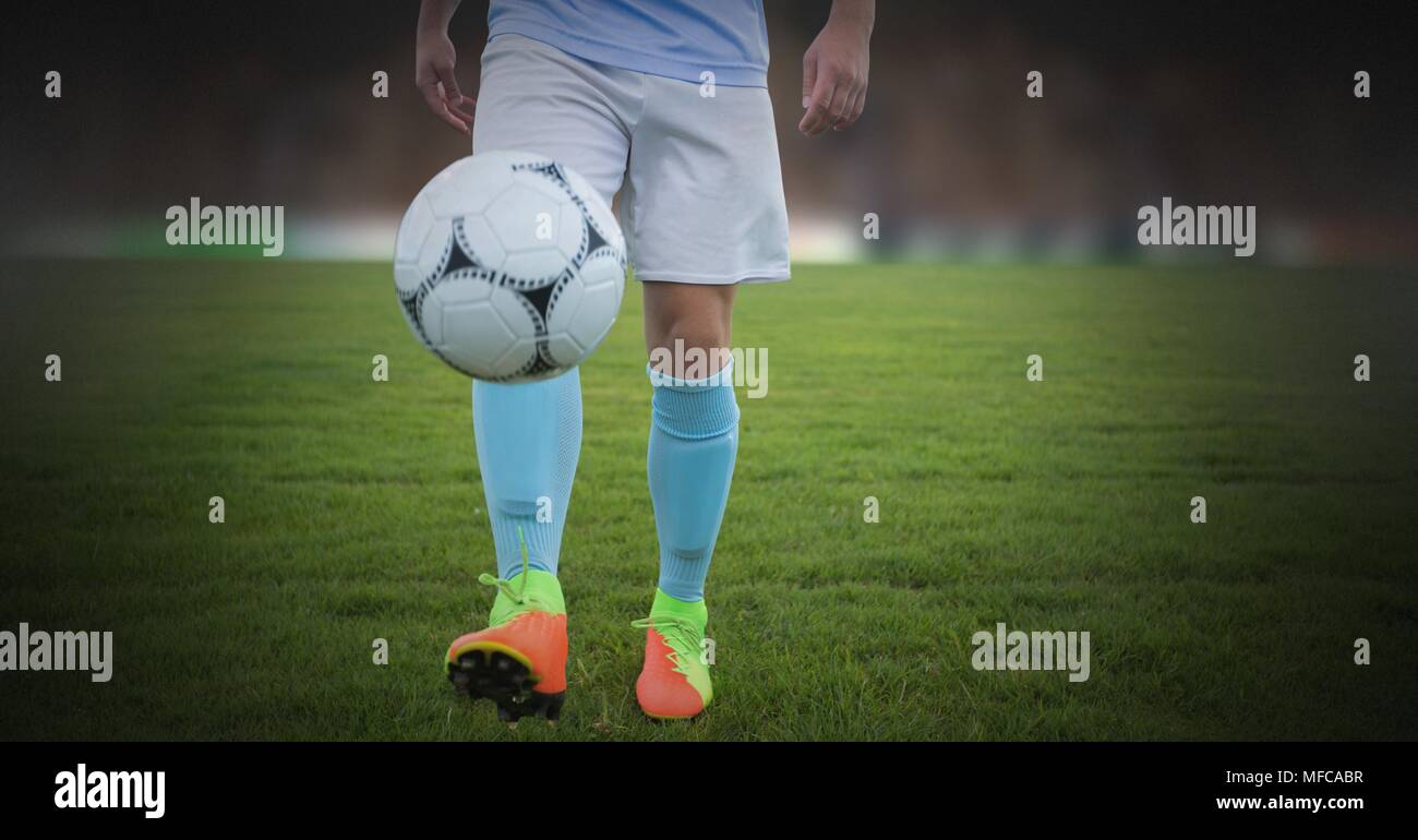 Giocatore di calcio in erba con il calcio da solo Foto Stock