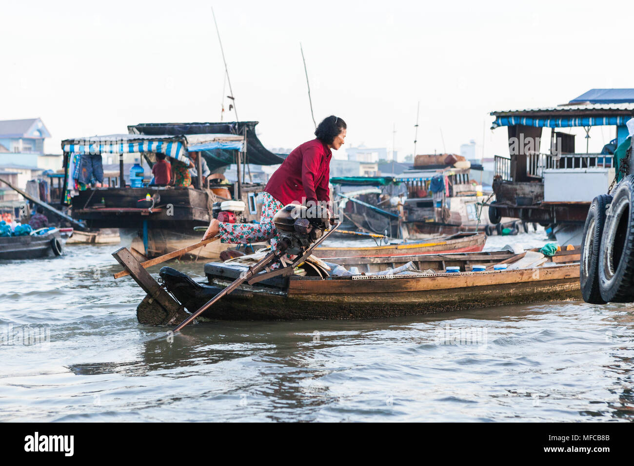 Can Tho, Vietnam - marzo 19 2017: donna locale dello sterzo è la sua barca usando la sua gamba, mercato galleggiante sul delta del fiume Mekong Foto Stock