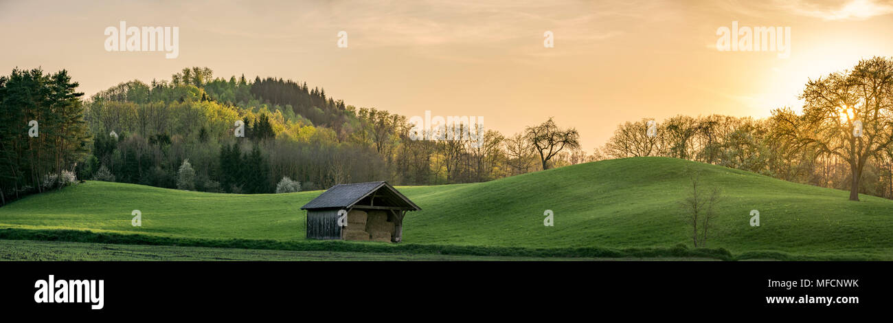 Panorama al tramonto con il verde delle colline e foreste sotto un cielo dorato, vicino alla città tedesca di Schwabisch Hall, Germania sud-occidentale Foto Stock