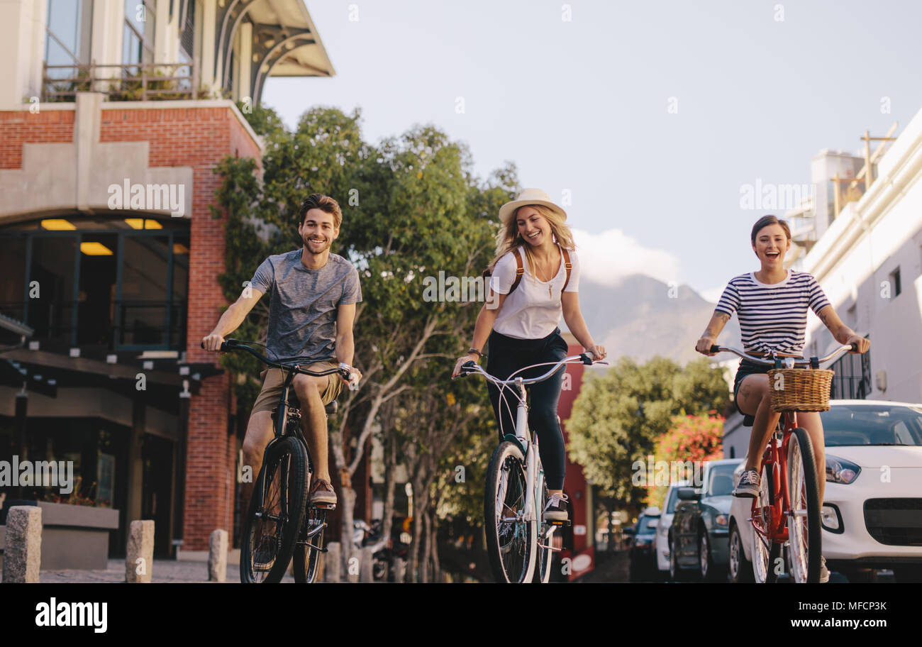 Gruppo di amici bicicletta equitazione all'esterno. L uomo e la donna in bicicletta in città. Foto Stock