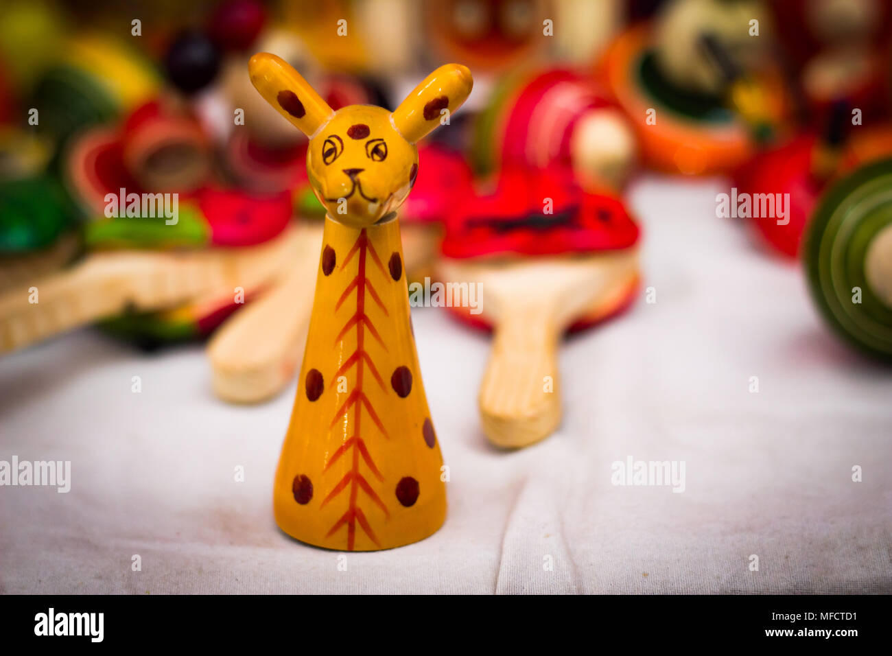 Un giallo giraffa in legno figura giocattolo vintage contro uno sfondo sfocato Foto Stock