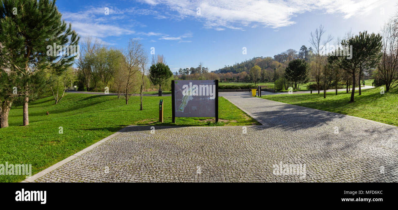 Vila Nova de Famalicao, Portogallo. Entrata del Parque da Devesa parco urbano costruito vicino al centro della citta'. Cobblestone pavement e information board Foto Stock