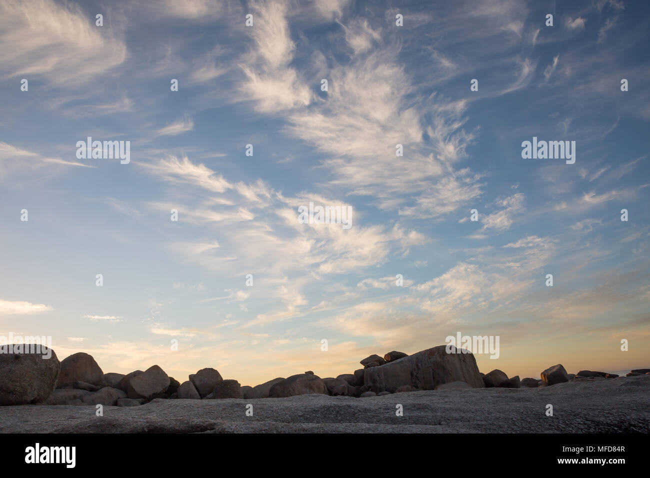 Formazioni di nubi al tramonto con rocce Foto Stock