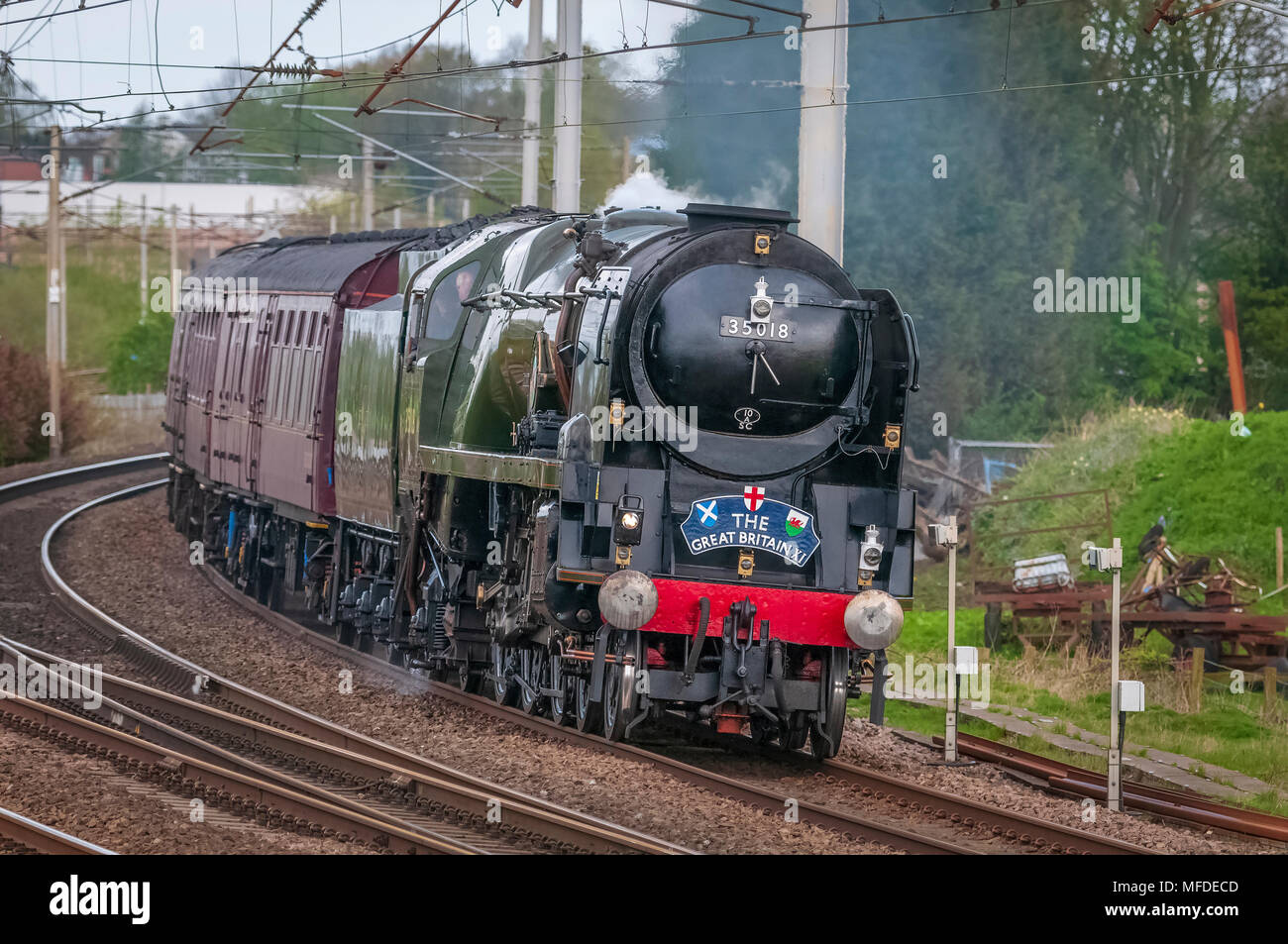 Winwick. United Kingdom. 25th. Aprile. 2018. La Gran Bretagna di bolina vapore railtour il giorno 7 del suo Round Britain viaggio. A partire fom Grange Over Sands il treno è stato legato per una sosta di una notte a Cardiff. Restaurato locomotiva a vapore n. 35018 l'India britannica linea visualizzata a velocità passando Winwick svincolo sulla linea principale della costa occidentale in rotta per Crewe. Credito: John Davidson foto/Alamy Live News Foto Stock