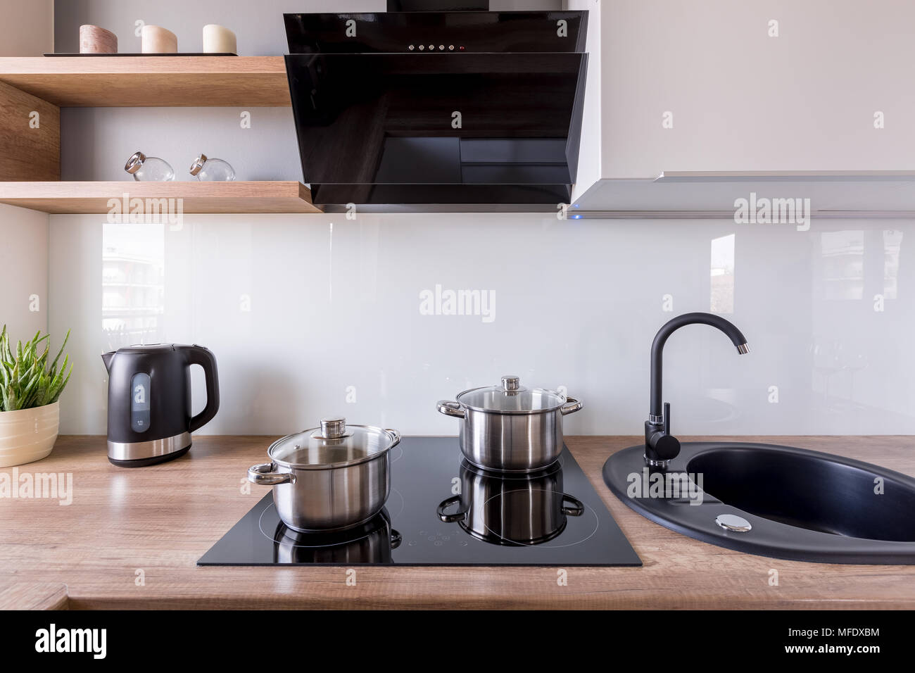 Cucina contemporanea con cappa di scarico e nuovo design nero lavello e  piano cottura a induzione Foto stock - Alamy