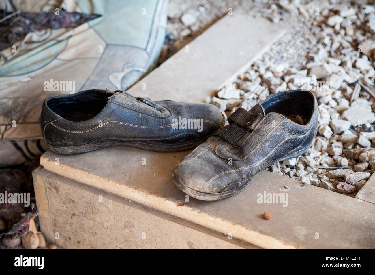 In prossimità di alcune scarpe in un abbandonato edificio bombardato a causa della guerra bosniaca di Mostar, Bosnia Erzegovina Foto Stock