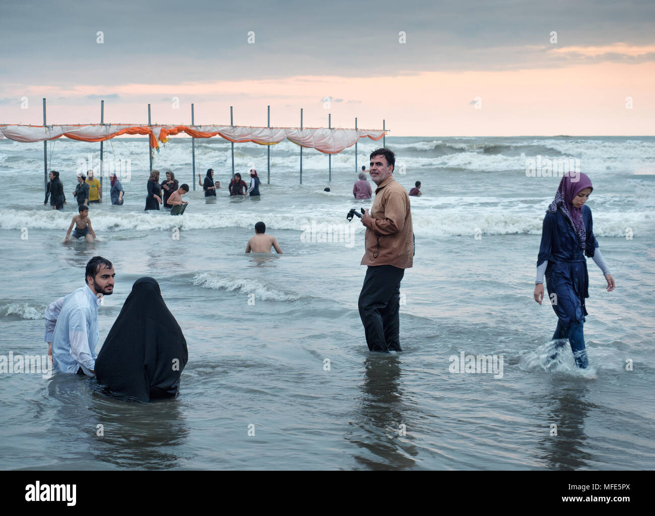 Babolsar, Iran - Luglio 23, 2016 : le persone godono di vacanze estive su una spiaggia dal Mar Caspio al tramonto Foto Stock