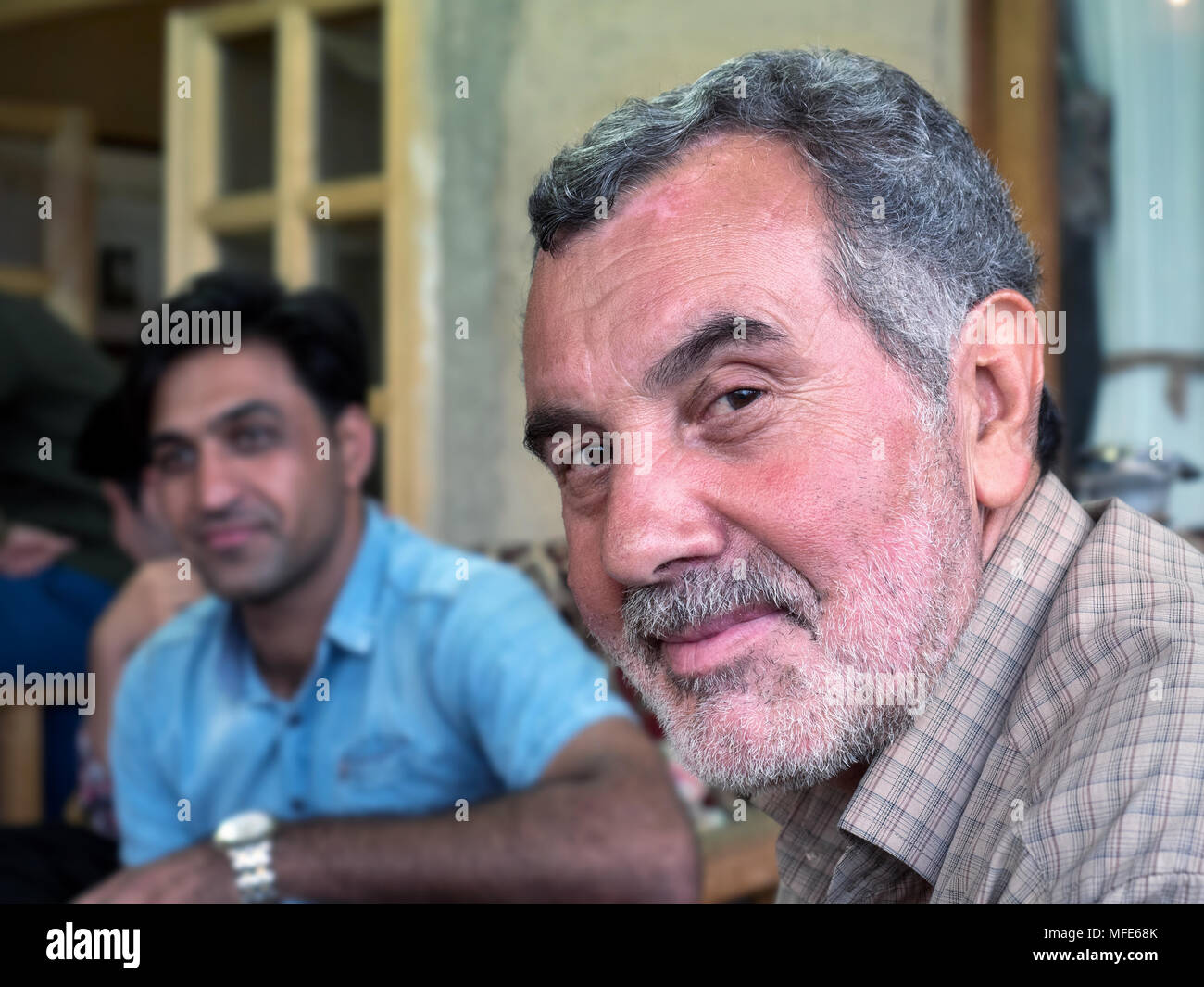 Kang, Iran - 30 Luglio 2016 : ritratto di un uomo iraniano con la sua famiglia in background Foto Stock