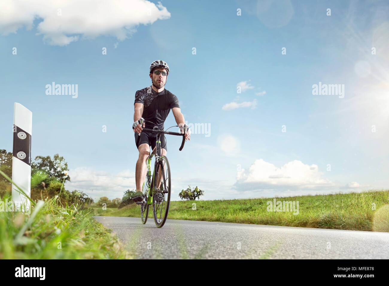 Ciclista su una strada piena di Sunny Foto Stock