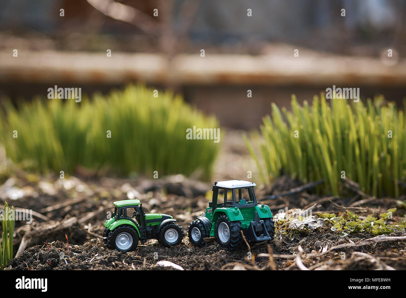 Trattore giocattolo su erba verde sfondo . Molla di opere di semina Foto Stock