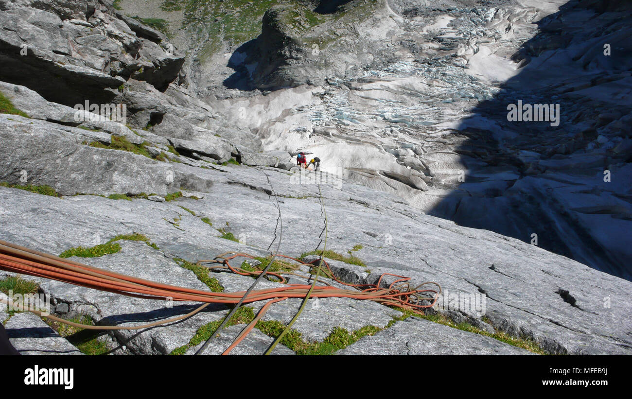 Guida di montagna su un disco di granito a salire un elevato picco alpino nelle Alpi Svizzere Foto Stock