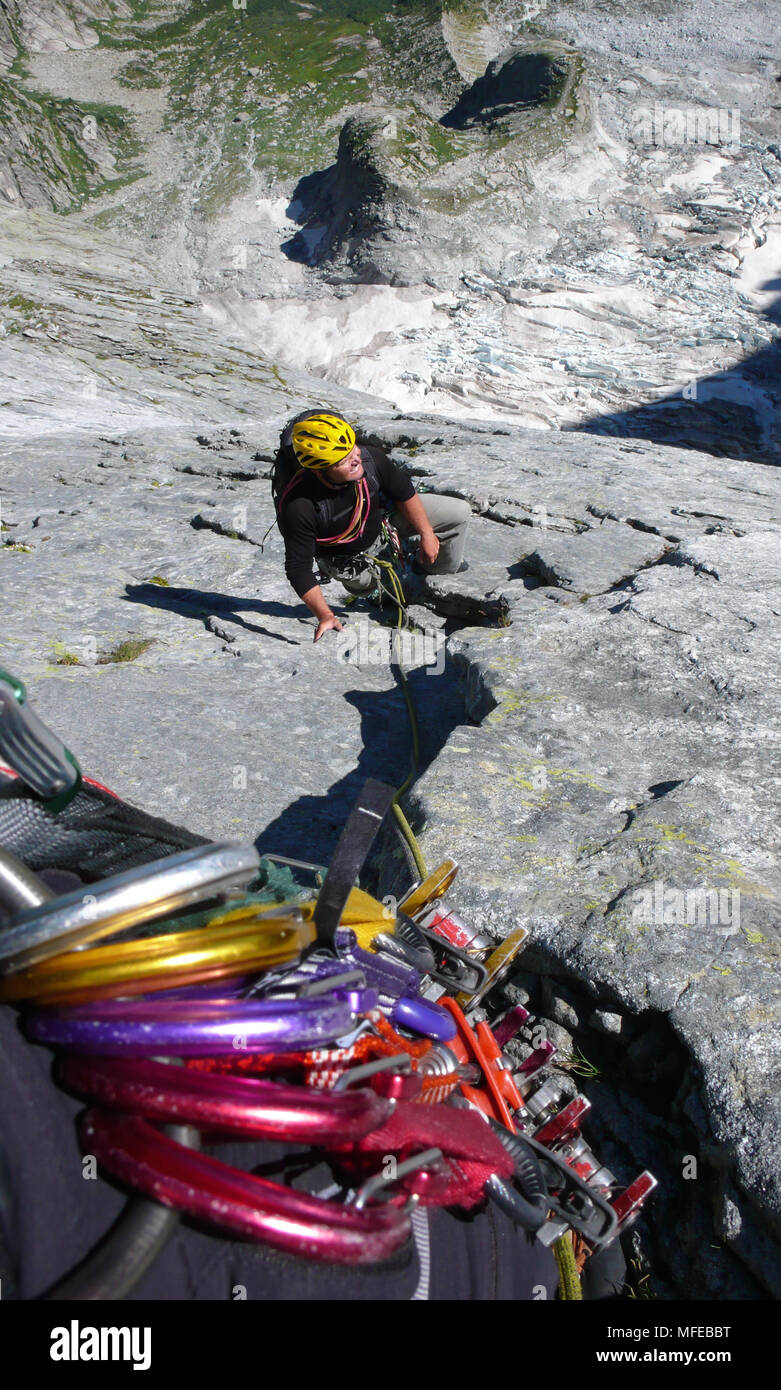 Guida di montagna su un disco di granito a salire un elevato picco alpino nelle Alpi Svizzere Foto Stock