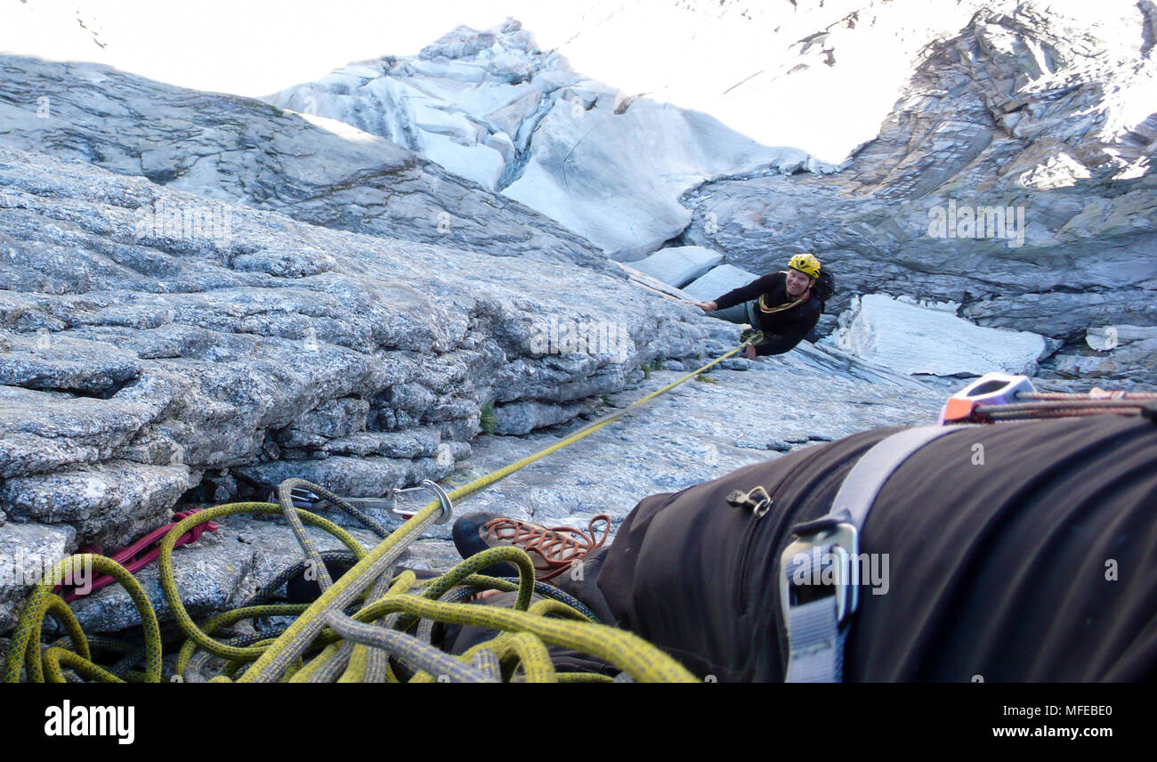 Guida di montagna su un disco di granito a salire un elevato picco alpino nelle Alpi Svizzere Foto Stock