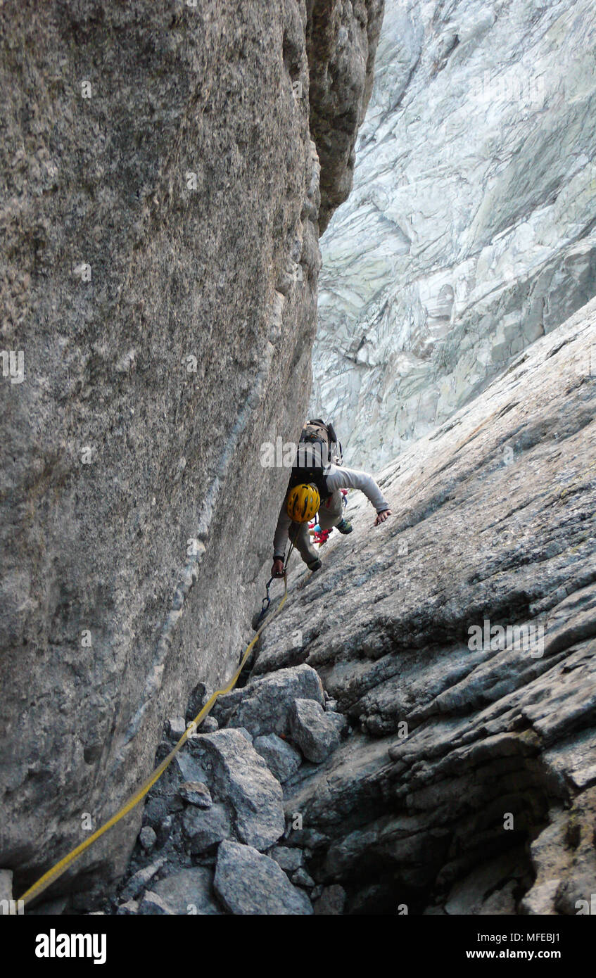 Guida di montagna su un disco di granito a salire un elevato picco alpino nelle Alpi Svizzere Foto Stock