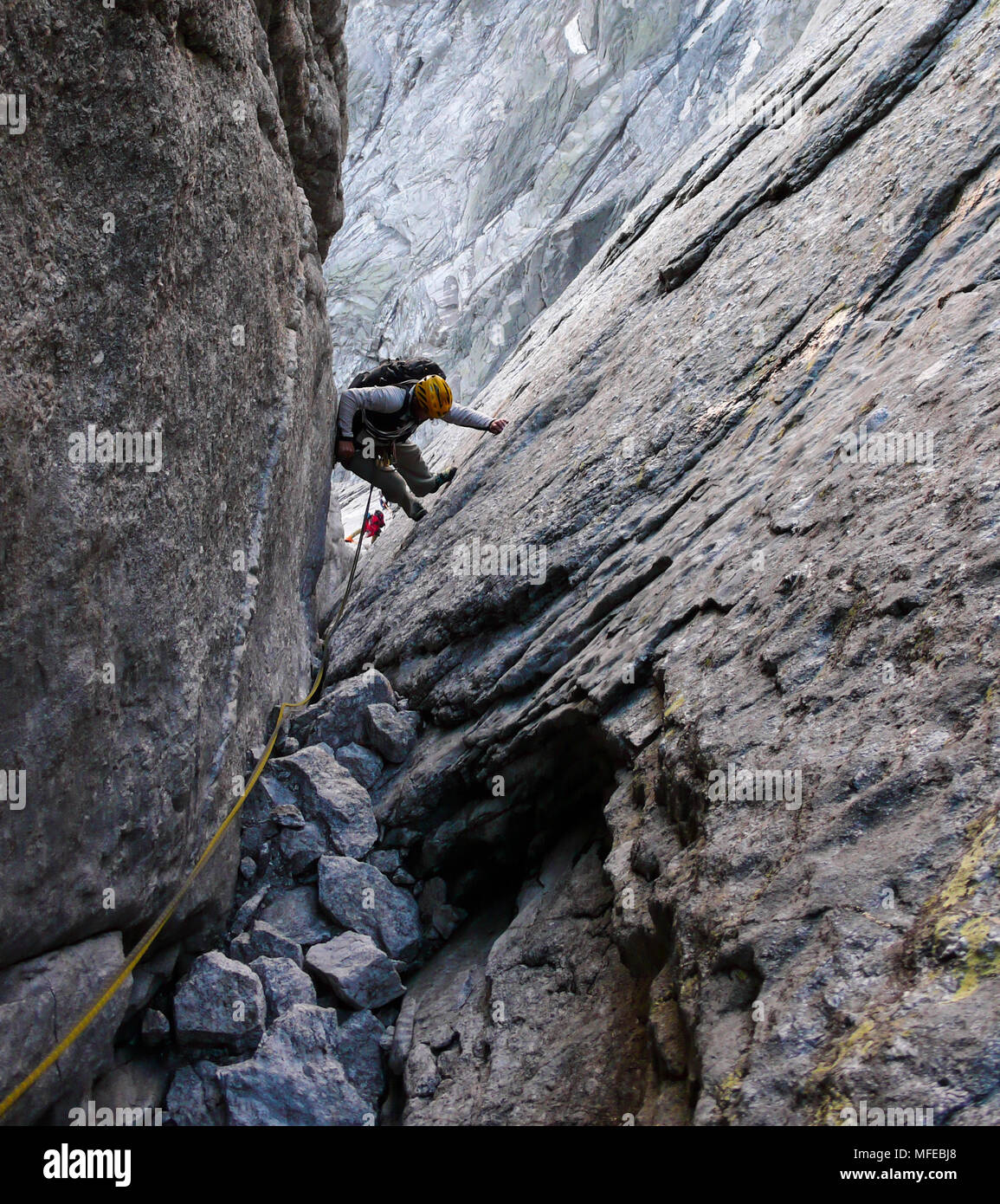 Guida di montagna su un disco di granito a salire un elevato picco alpino nelle Alpi Svizzere Foto Stock