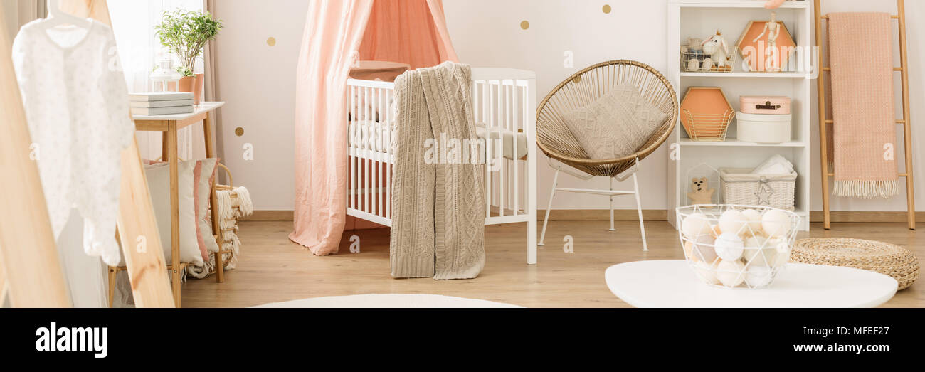 Oro poltrona accanto al presepe bianco con coperta in rosa cameretta del bambino interiore con scaletta Foto Stock