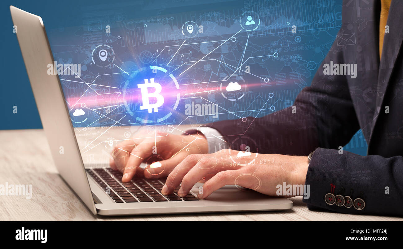 Controllare a mano sul laptop bitcoin globale Tasso di cambio concept Foto Stock