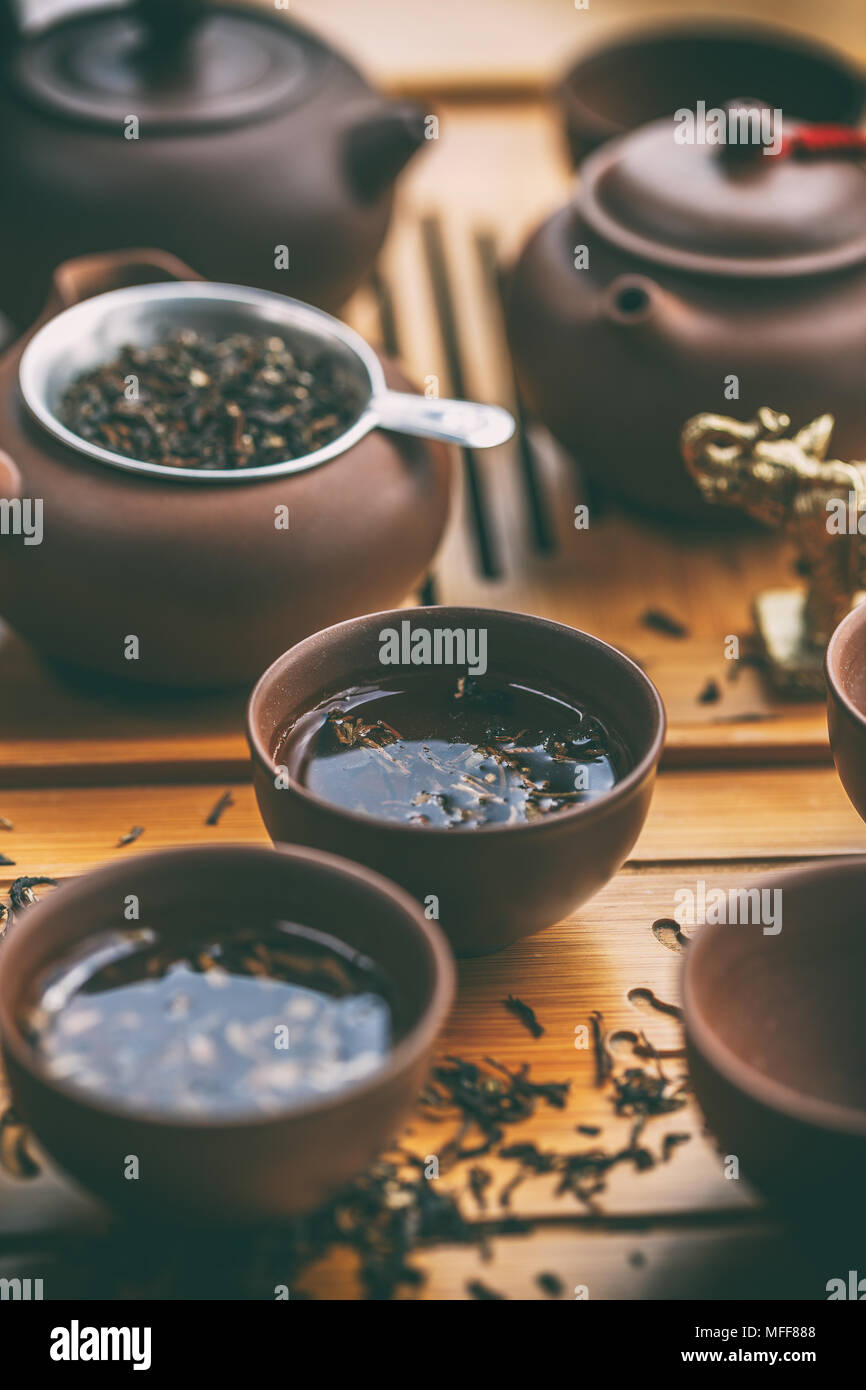 Cerimonia del tè cinese. Il tè in ceramica pentola e tazze con il nero le foglie di tè Foto Stock