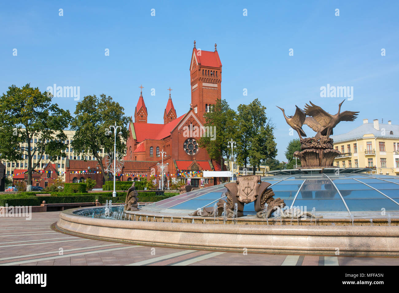 Chiesa dei Santi Simone noto anche come la Chiesa Rossa e la fontana con il nome della città bielorusse Brest su di esso a Piazza Indipendenza a Minsk, in Bielorussia. Foto Stock