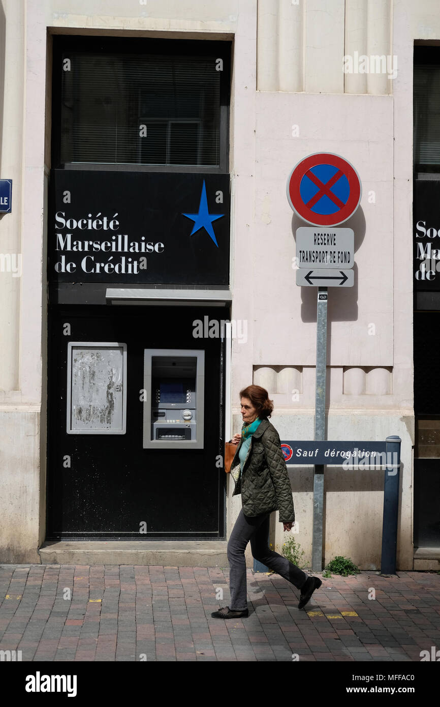 Una donna camminare davanti a un societe Marseillaise de banca di credito Foto Stock