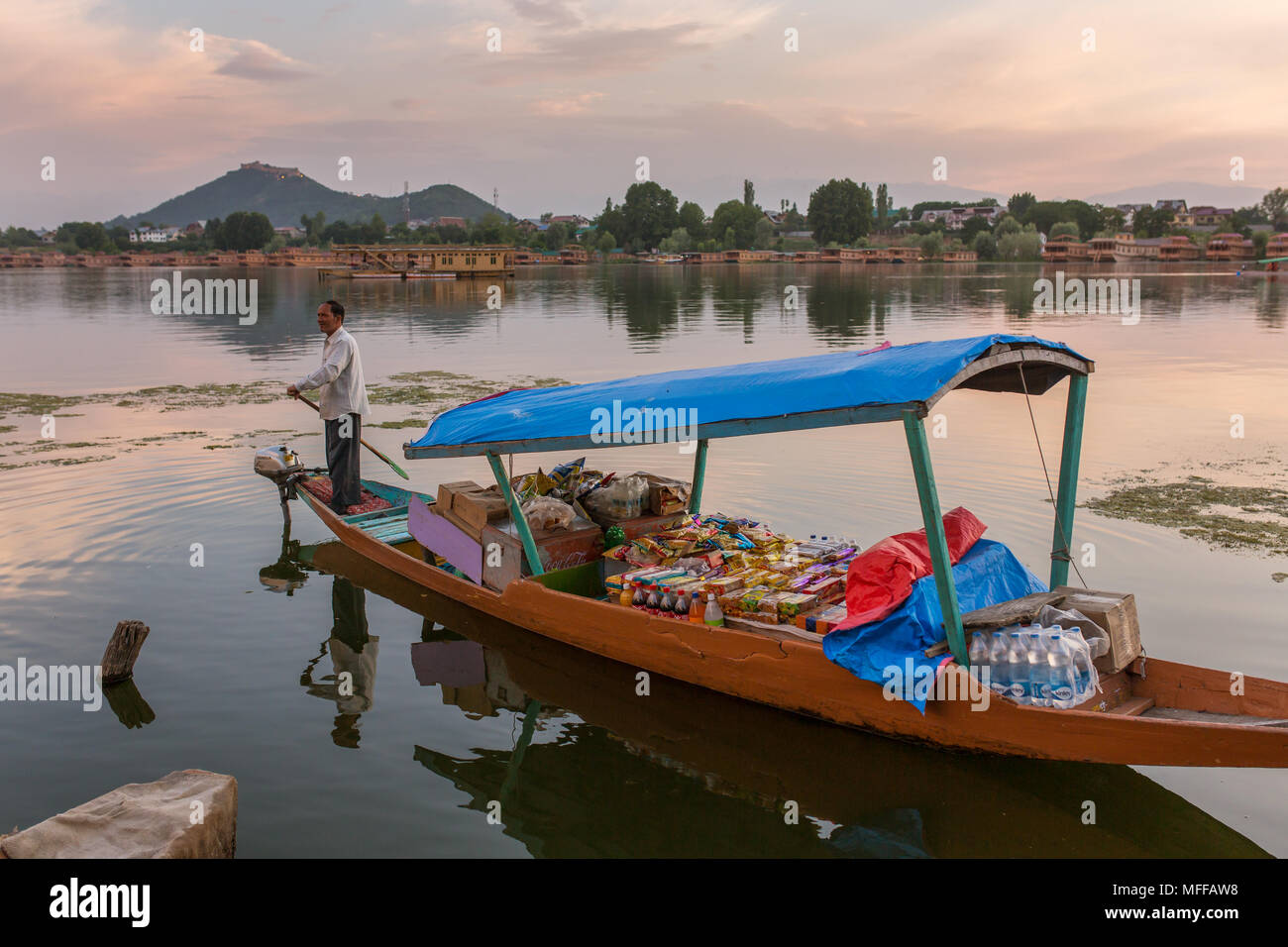 Srinagar, India - 13 Giugno 2017: Non identificato uomo kashmir vendita di negozio di generi alimentari per i turisti dalla sua barca sul lago Nagin a Srinagar. Foto Stock