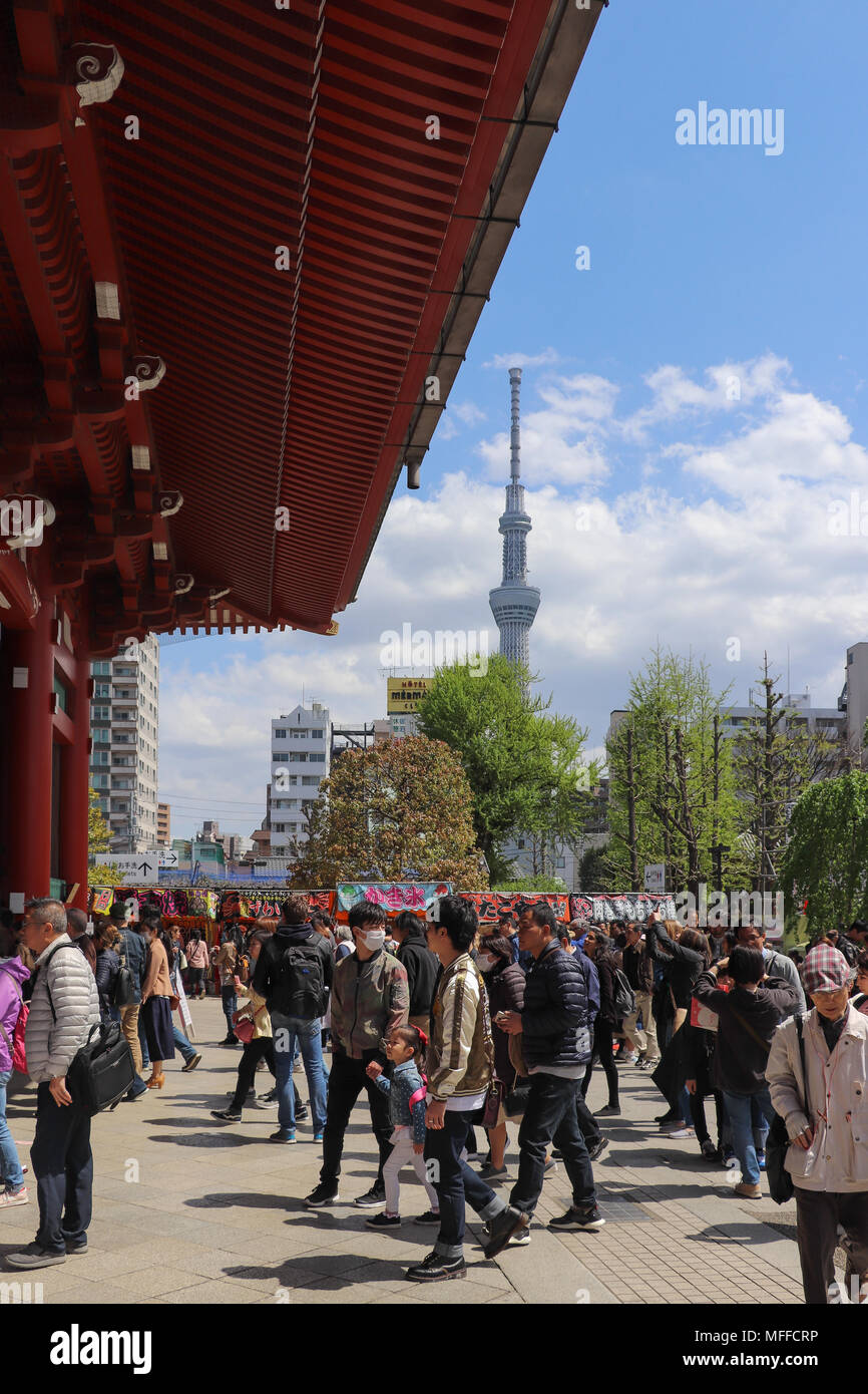 La folla immettere il tempio di Sensoji complessa attraverso il Kaminarimon Gate per Nakamise-dori in una giornata di sole in Giappone: Tokyo Skytree in background, nuvole. Foto Stock